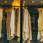 Curated high-fashion garments in neutral monochrome ecru and beige tones
