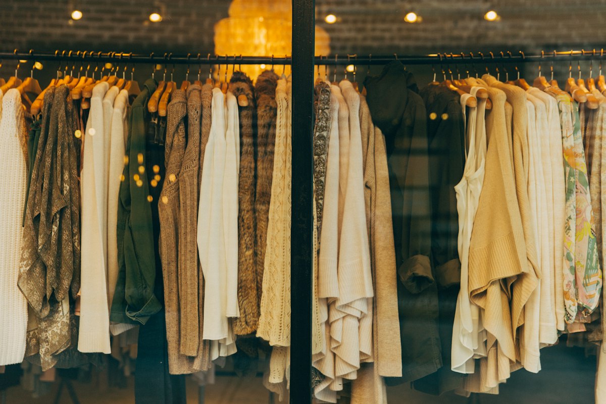 Curated high-fashion garments in neutral monochrome ecru and beige tones