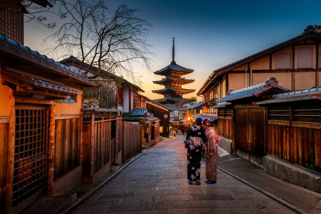 Historic Kyoto wooden temple surrounded by lush Japanese maple trees